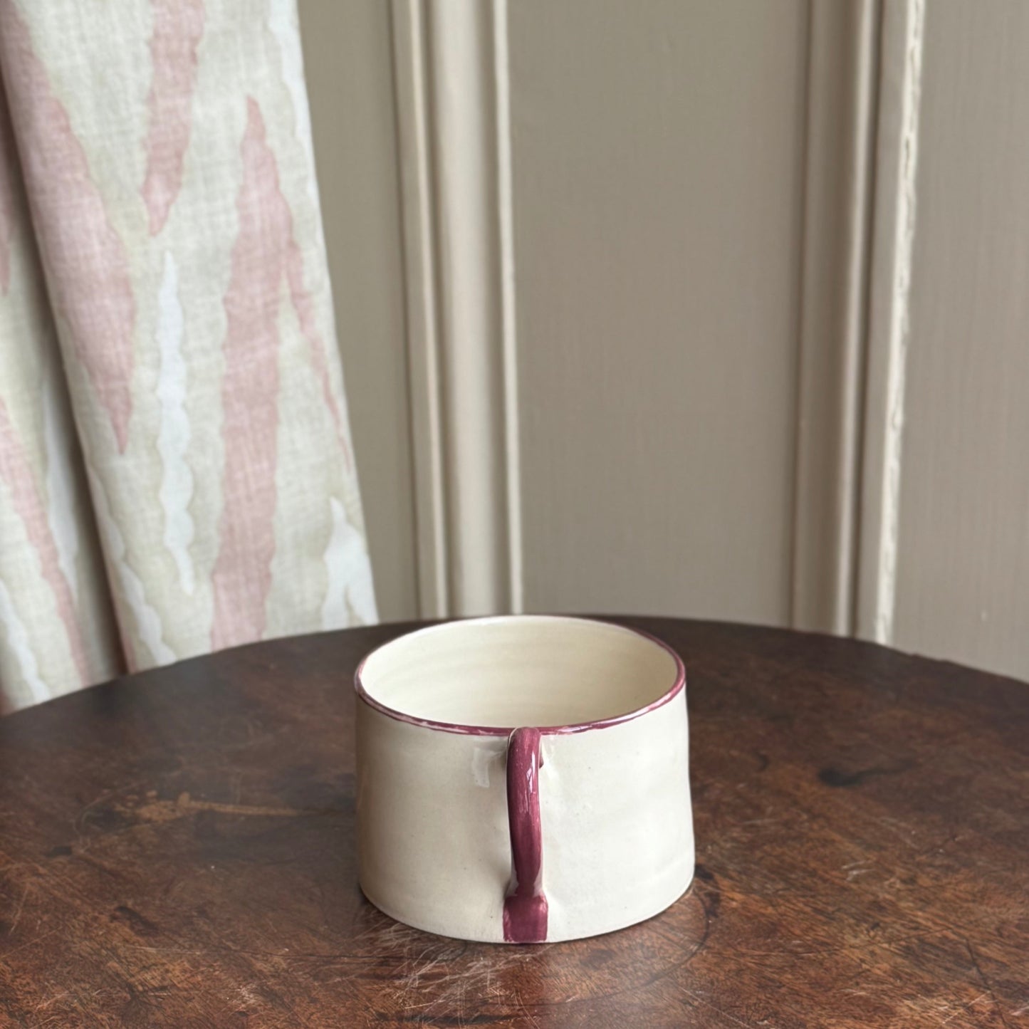 Ceramic mug hand painted with a burgundy rim and handle