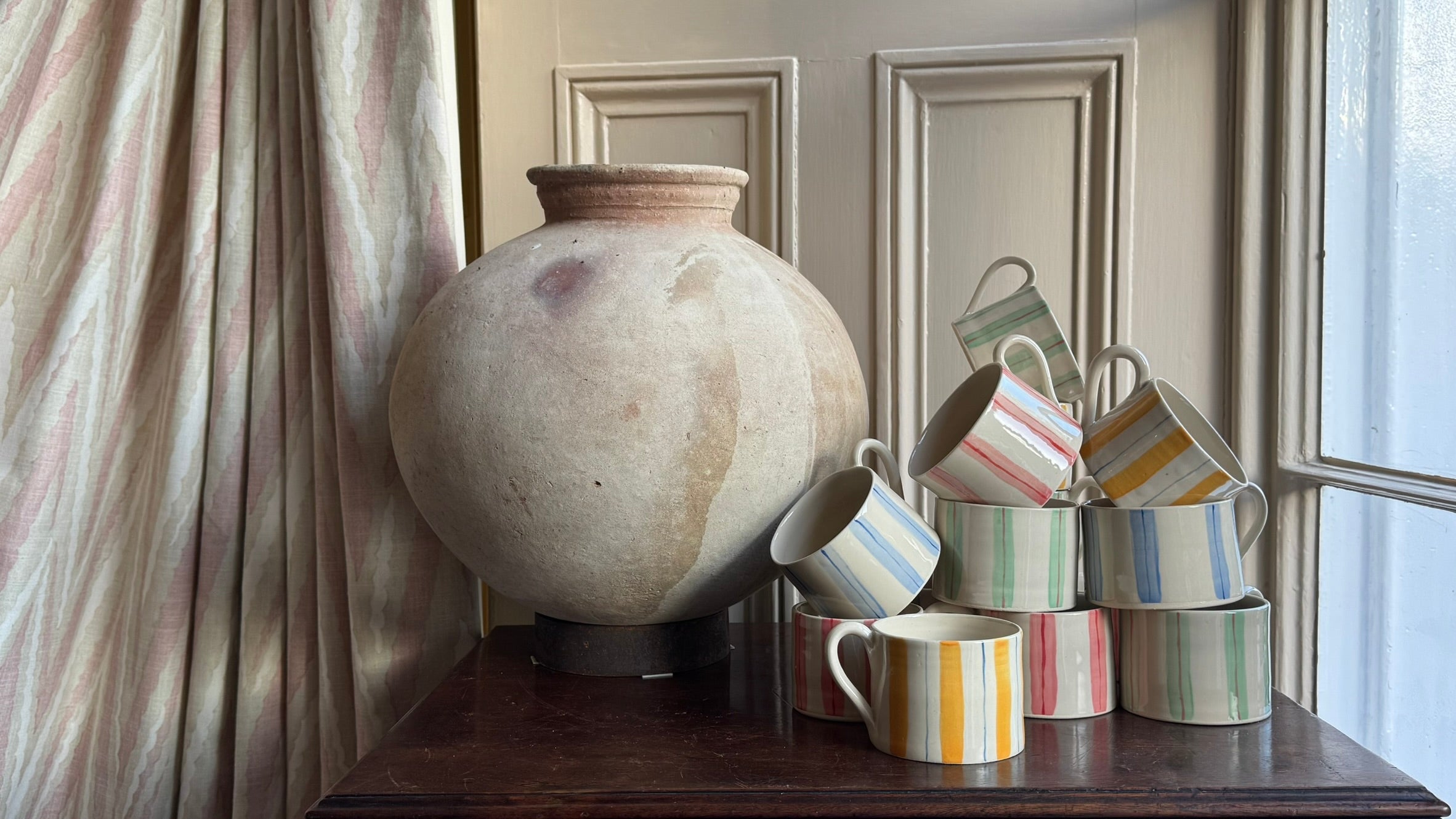Handmade stoneware mugs that have been hand painted in stripes