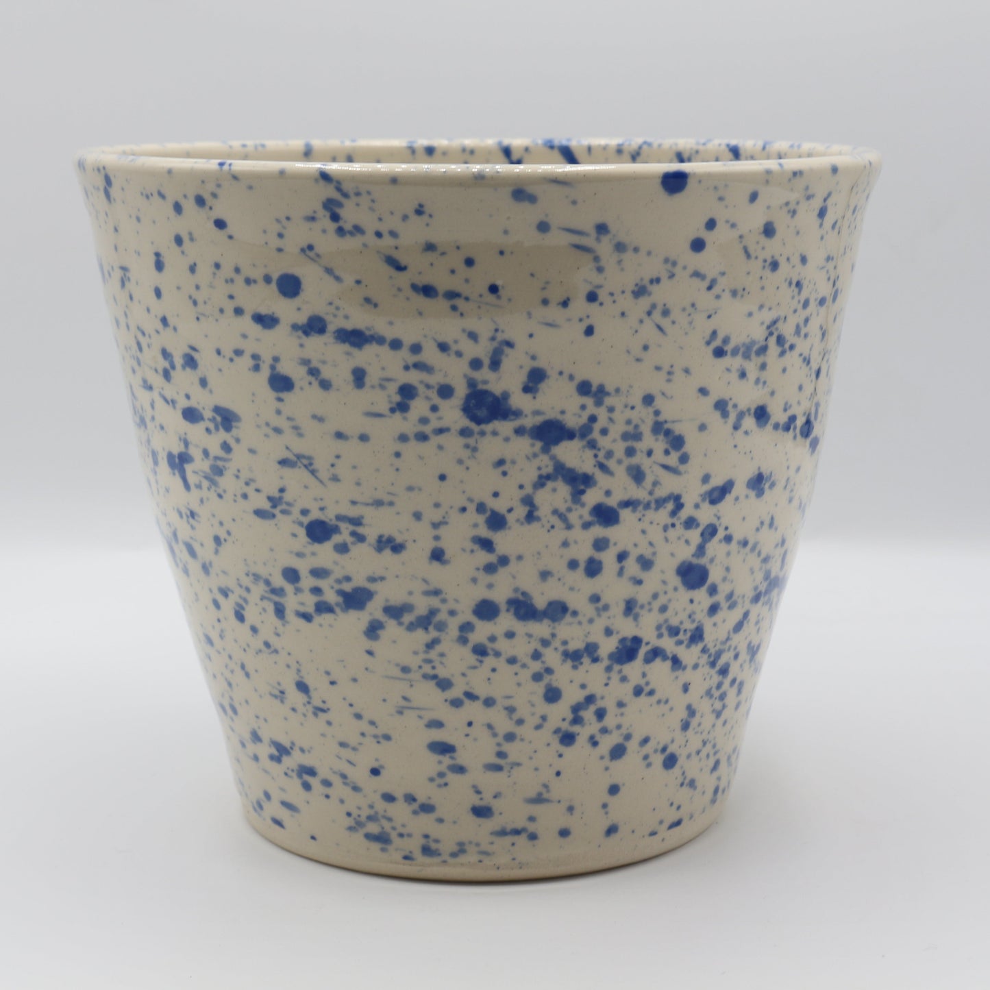 Ceramic pot with blue speckles on a white background