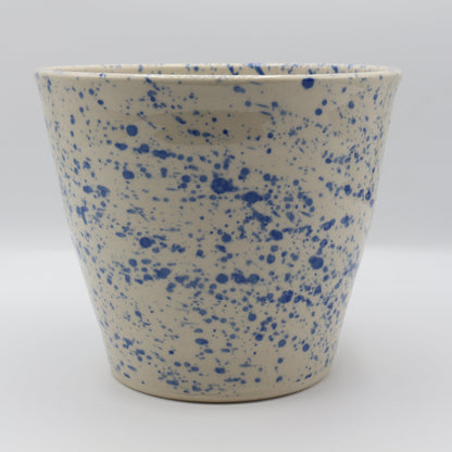 Ceramic pot with blue speckles on a white background